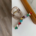 Detailaufnahme der braunen Haarklammer mit bunten Herz-Strasssteinen und goldener Metallfeder - Kleiner V-Form Stil