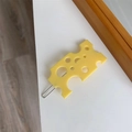 Dettaglio di un fermaglio creativo a forma di formaggio giallo con base in metallo - Quadrato