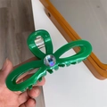 Detail of handmade green bow hair claw with iridescent crystal and gold logo - Green