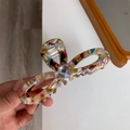 Close-up of floral acetate bow hair claw clip with a sparkling center rhinestone detail - Retro Floral