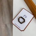 Close-up of handmade dark wooden beaded ring with natural wood grain texture on card - Grey Black Round Stone
