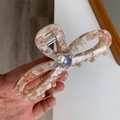 Macro detail of the acetate bow hair claw with marble texture and sparkling rhinestone - Pink Floral Pattern