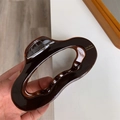 Detailaufnahme der dunkelbraunen Acetat-Haarklammer mit wellenförmigem Oval-Design - Braun