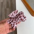 Gros plan sur une pince à cheveux rose à motif léopard en résine brillante - Léopard Rose