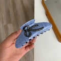 Dettaglio della pinza per capelli in denim azzurro con fiocco di strass in mano - Stile Fiocco Blu Denim Chiaro / Lunghezza 10.5cm Larghezza 4.5cm