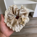 Detalle de coletero de terciopelo beige con bordes de encaje y colgante de metal dorado - Beige