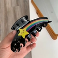 Nahaufnahme der schwarzen Acetat-Haarklammer mit Regenbogenstreifen und gelbem Stern - Schwarz