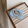 Detail van blauwe haarklem met witte hartsterren en amberkleurige spiraalvormige patronen - Koffie Blauw Serie