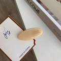 Detail of a creamy acetate hair clip with France Handmade text on a magazine background - Beige Duckbill Clip