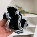 Détail du chouchou en velours noir avec bordure en dentelle blanche et broderie florale - Chouchou noir