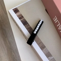 Dettaglio dell'elegante fermaglio in velluto nero con sette perle bianche per capelli - Stile Multi-Perla