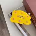 Detail of cute yellow cheese hair claw clip with smiling face on decorative books - Yellow