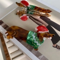 Detail van de dachshund haarklem van acetaat met kerstmuts en groen feestelijk patroon - Kerst Teckel Haarklem