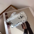 Detalle de la pinza para el pelo de acrílico crema con diseño de perro en una revista - Perro de Línea