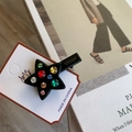 Détail d'une pince à cheveux en forme d'étoile avec strass colorés sur carte de vente - Clip Latéral Étoile Noire