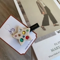 Détail macro d'une barrette étoile avec strass colorés sur une base pentagramme crème - Clip Latéral Étoile Beige