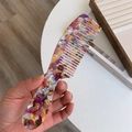 Detailed macro view of acetate marble texture on colorful wide-tooth hair comb accessory - Retro Floral