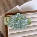 Detailed view of teapot shaped acetate hair claw clip with green marble texture - Green Spout Style