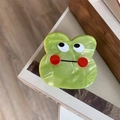 Detailed macro view of the cute green frog acetate hair claw clip with marble texture - Frog
