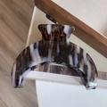 Macro detail of large acetate hair claw with brown and white marble texture on wood - Tricolor Marble Moon Claw