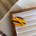 Detailed macro view of acetate hair clip with colorful stripes, bow, and rhinestone accents - Yellow Bow Side Clip