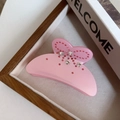 Pince à cheveux papillon rose élégante avec strass sur un plateau décoratif - Rose