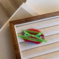 Macro shot of striped acetate hair clip with green silk bow and rhinestone details - Green Bow Side Clip