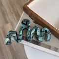 Detail of oversized marble acetate hair claw clip with wavy edges and green texture - Blue Black Wave Claw Clip