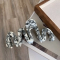 Dettaglio della clip per capelli ondulata in acetato con motivo astratto bianco e nero - Pinza a Onde Bianco e Nero