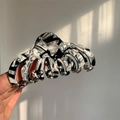 Large marble texture acetate hair claw clip for thick hair shown in hand with sunlight - Black And White Textured (L1-022CL)