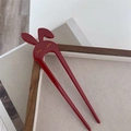 Detalle de horquilla en U de conejo rojo con patrones de pestañas doradas en bandeja - Rojo