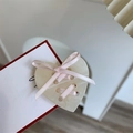 Detalle de un botón de resina en forma de corazón con un lazo de cinta de raso rosa - Pinza Lateral Corazón Beige (5484797415788)
