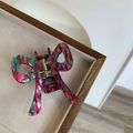 Dettaglio della molletta per capelli in acetato con motivi geometrici colorati e molla d'oro - Pois Rossi e Verdi