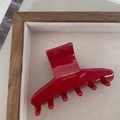 Dettaglio della pinza per capelli in acetato rosso con scritta dorata in un portagioie - Rosso Puro