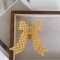 Detail view of yellow checkered ribbon hair claw clip on a felt display tray - 8cm x 4cm / Yellow Plaid