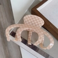 Makroaufnahme der großen beige-rosa karierten Haarklammer auf hellem Holzgrund - Beige Karo Haarkralle