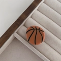 Detalle de una pinza para el cabello de resina brillante con textura de baloncesto naranja y negra - Red Lines Ball