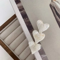 Detail view of cream marbled resin hair clip with three heart-shaped motifs - White
