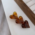 Detail of three-heart tortoise shell resin hair clip with polished finish and metal base - Caramel color