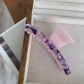 Detail view of pink and purple floral cellulose acetate hair claw clip in a jewelry box - Purple Textured