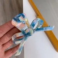 Nahaufnahme der Haarspange mit Schleife aus Acetat mit Marmortextur in Blau und Beige - Metallblau