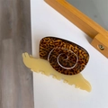 Detail van slakvormige haarklem gemaakt van crème en schildpadkleurig acetaatmateriaal - Gele Slak
