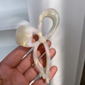 Detail showing high-quality iridescent bow hair claw with a pearlescent finish held by hand - White Enamel