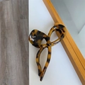 Dettaglio macro della molletta per capelli a fiocco con finitura lucida in tartaruga - Stampa Leopardata Scura