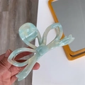 Detail of mint green acetate hair claw clip with bow design and marble texture - Light Blue-Crown Shape