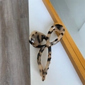 Dettaglio macro della pinza per capelli in acetato tartarugato con design a fiocco vuoto - Leopardo Chiaro