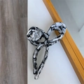 Dettaglio della trama marmorea e del design curvo della grande clip per capelli in acetato - Marmo Bianco e Nero