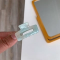 Close-up of mint green acetate hair claw clip with marble texture and rectangular hollow design - Light Blue-Small Rectangle