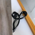 Dettaglio della molletta per capelli nera lucida a forma di fiocco con presa forte - Nero