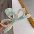 Detail view of large acetic acid bow hair claw clip in green and white marble texture - Light Green Texture